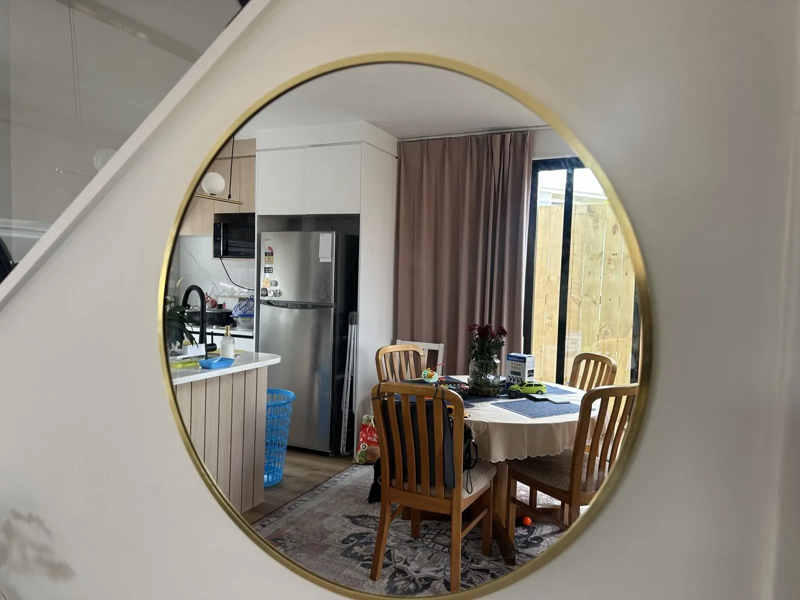 Round gold-framed mirror hung on the same wall in Pakuranga