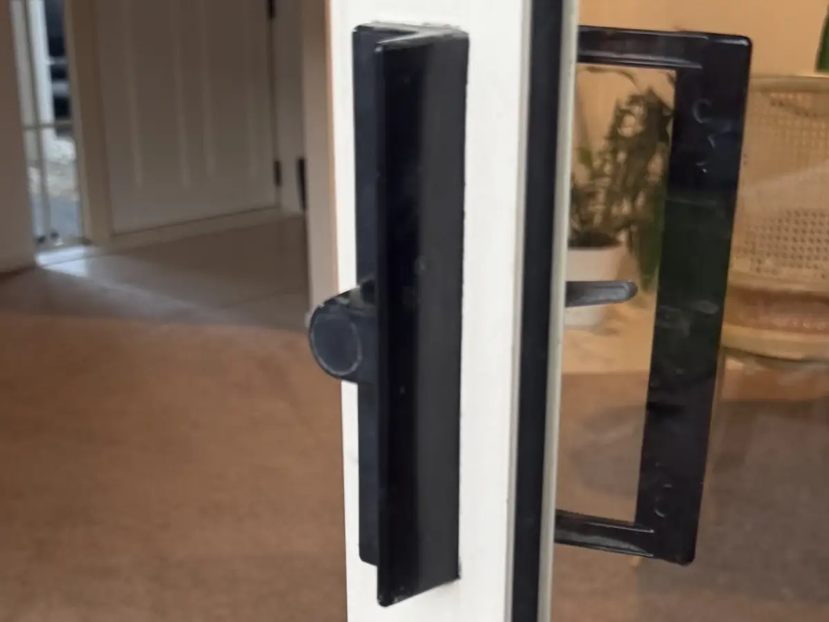 Old black sliding door lock in Botany with a blind plug filling the hole where a key barrel would sit