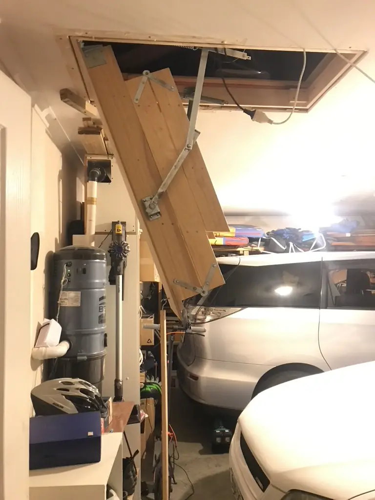 New pull-down manhole ladder in the Golflands garage part way through unfolding from the ceiling