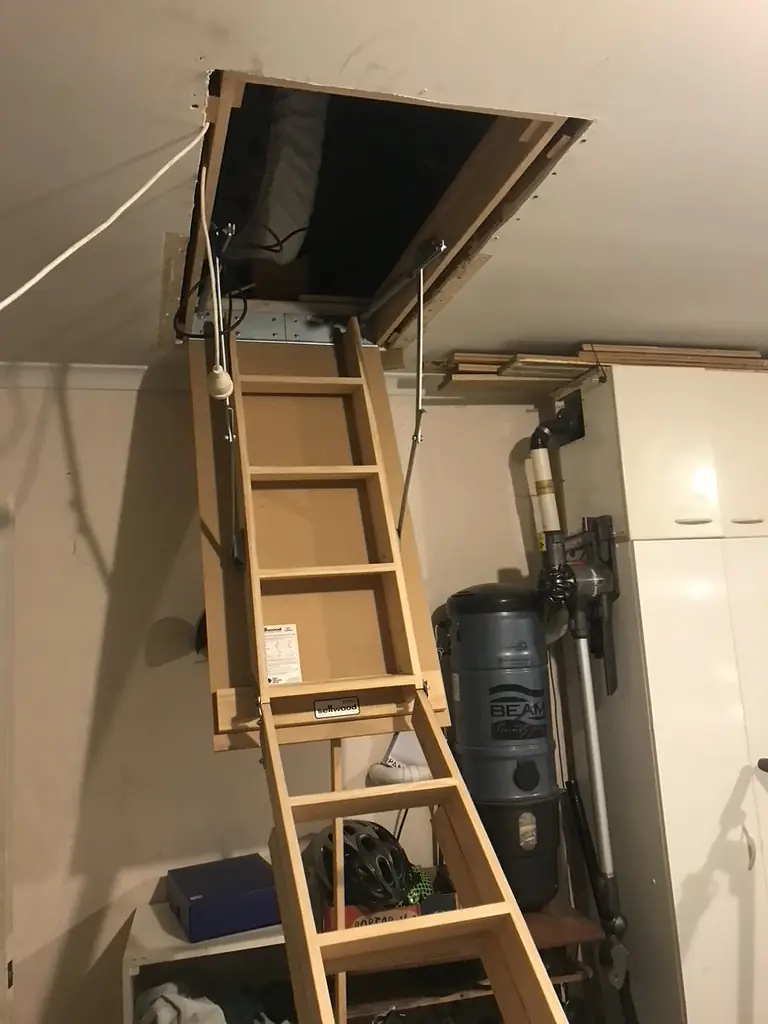 Pull-down manhole ladder installed in a Golflands garage, fully extended to the floor
