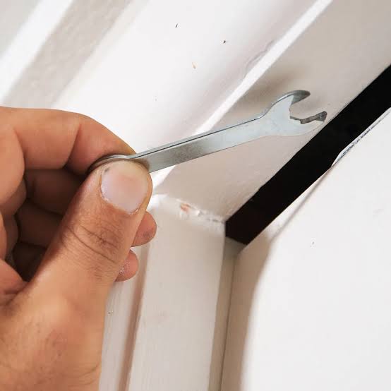 Using the door's adjustment key on the roller hinge to level the cavity sliding door