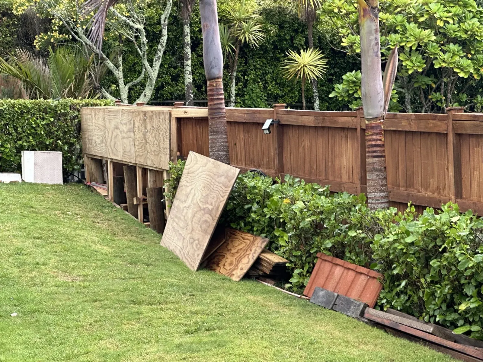 Timber frame being constructed for a custom garden storage shed beside a fence