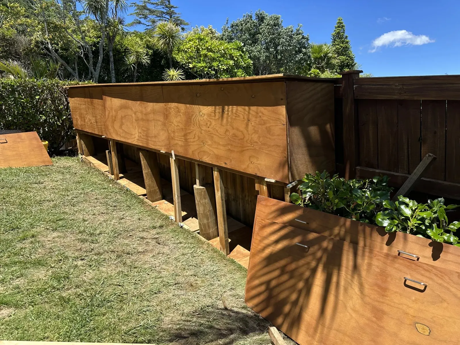 Stained custom garden storage shed showing separate open storage doors