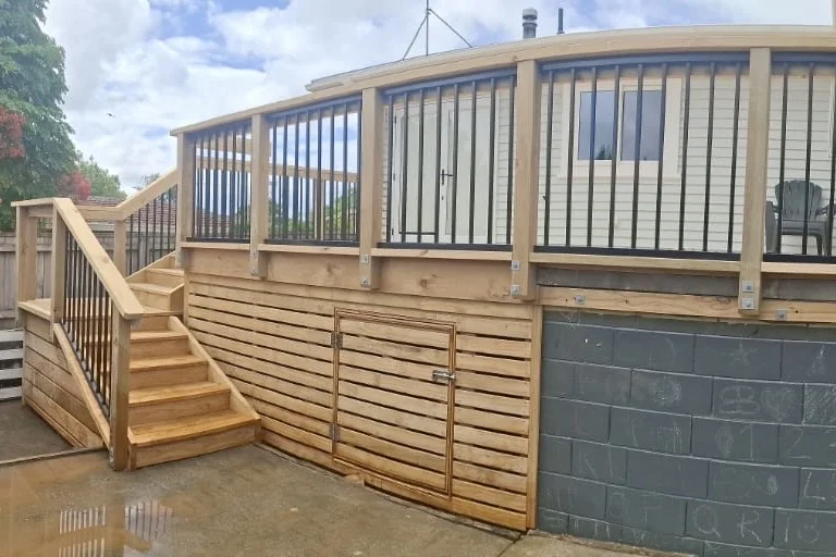 The completed deck seen from the yard, showing steps and slatted skirting with access hatch