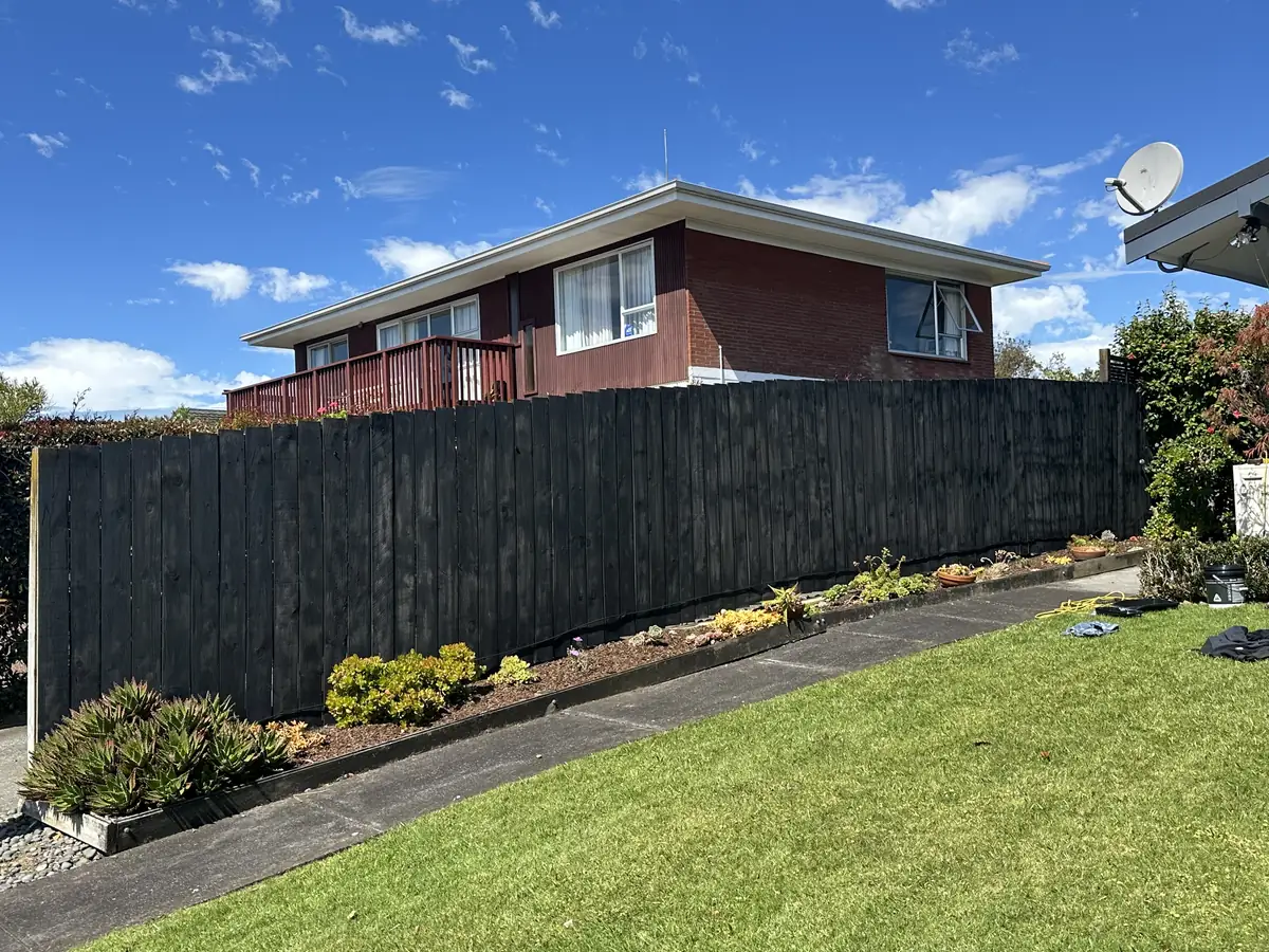 Long timber paling fence in Pakuranga Heights sprayed black by Handyman Botany