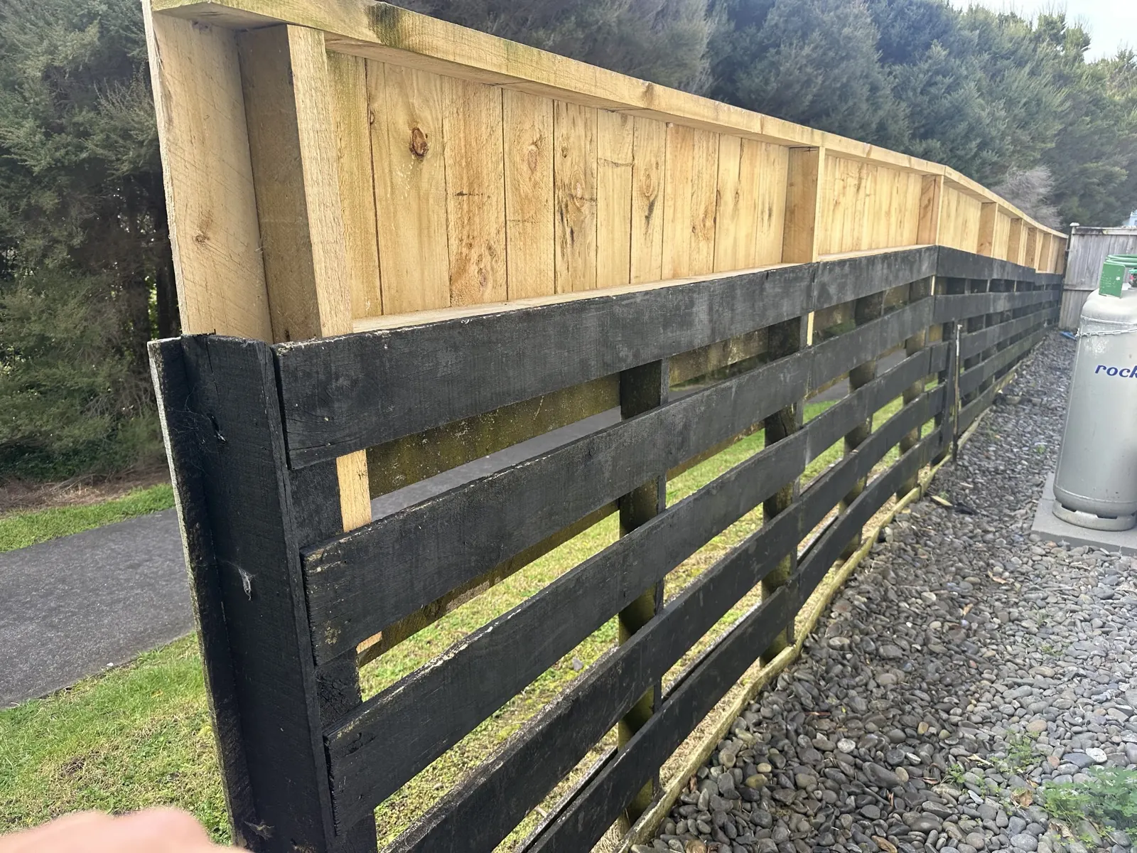 House side of the fence after water blasting, showing new palings above the washed original rails