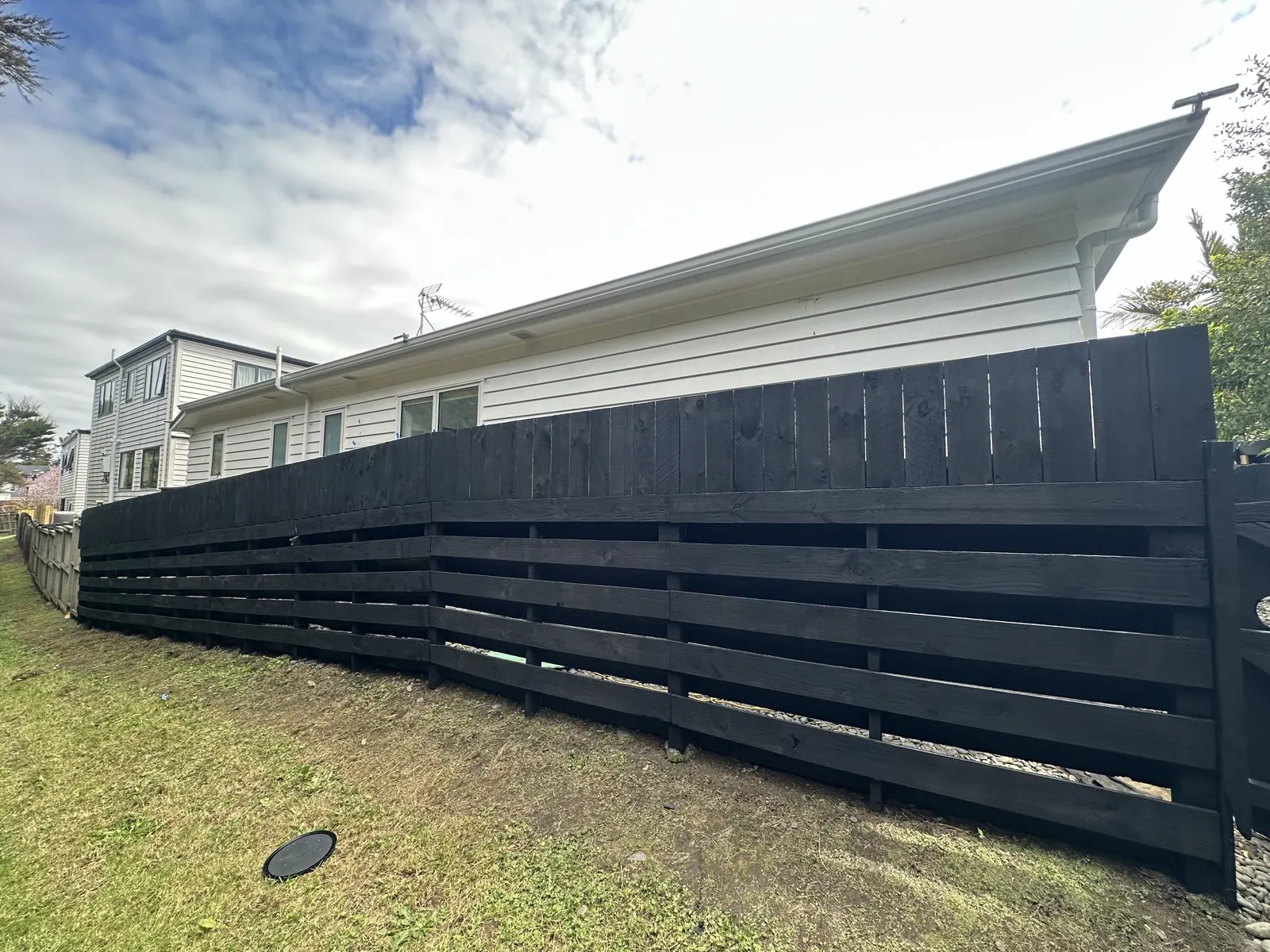Black painted boundary fence in Sunnyhills after water blasting and repainting