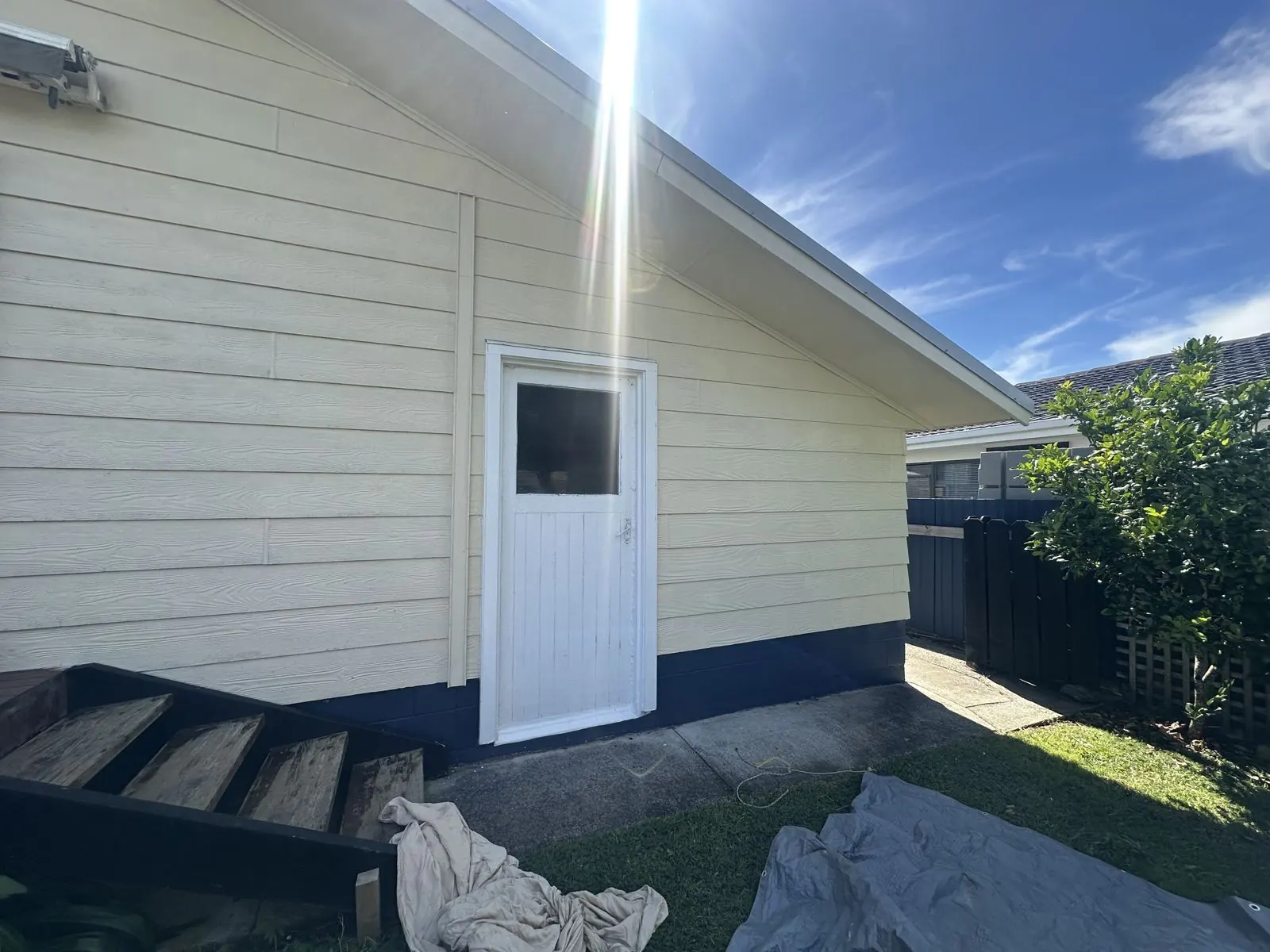 Old warped timber front door before replacement in Half Moon Bay, East Auckland