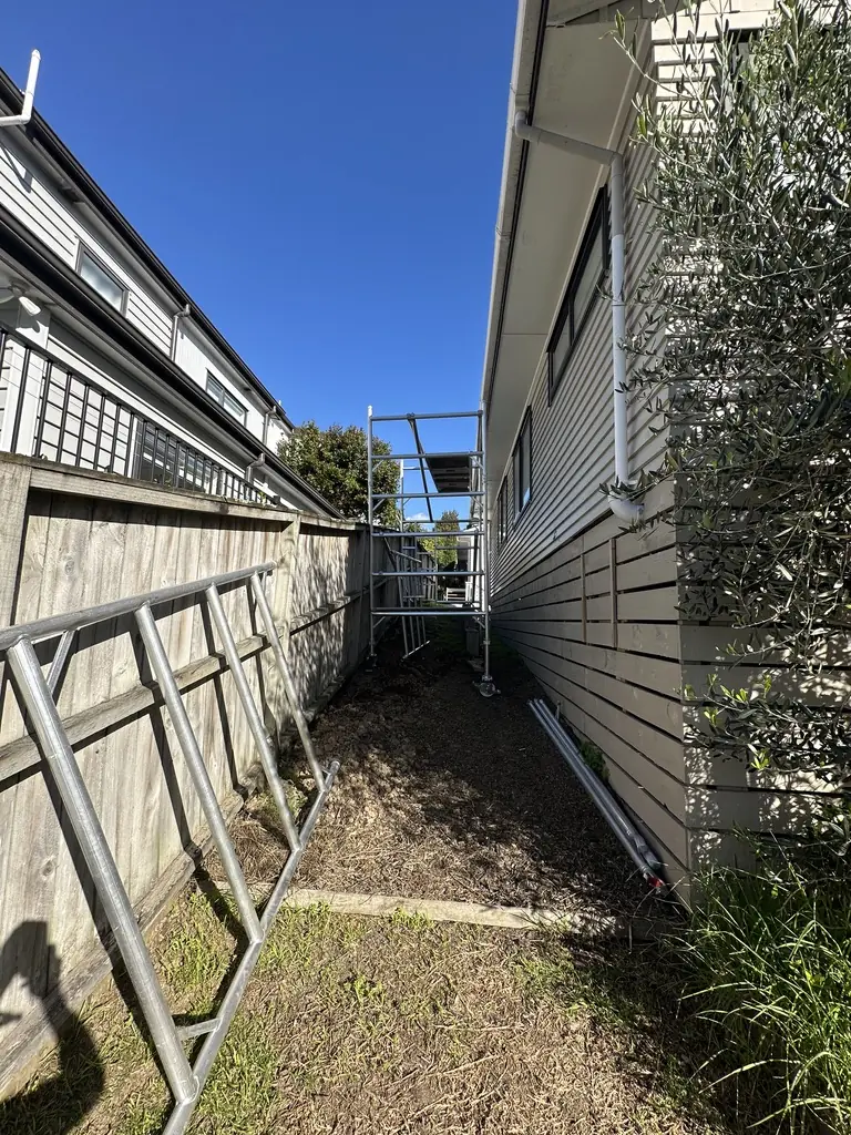 Mobile scaffold tower erected in the narrow side passage of the Howick house for safe access to the gutter