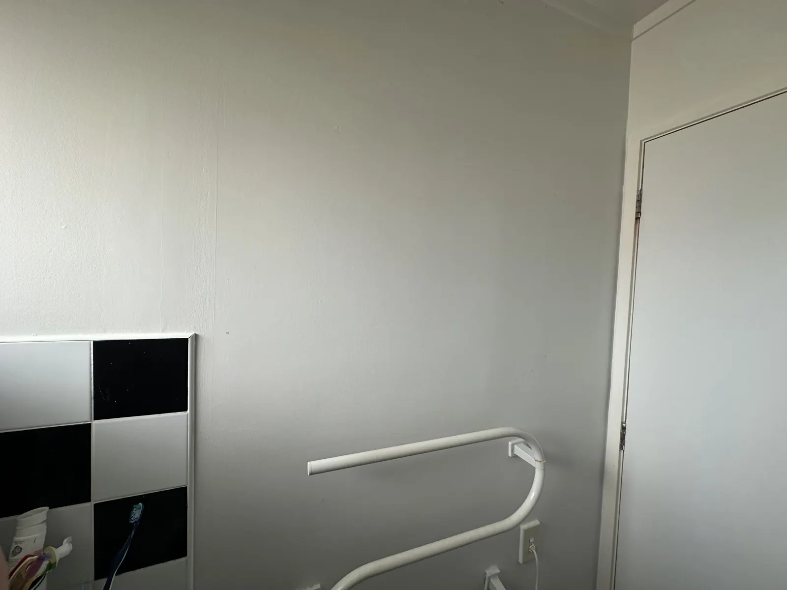 The bathroom wall after the old mirror was taken down, clean and painted