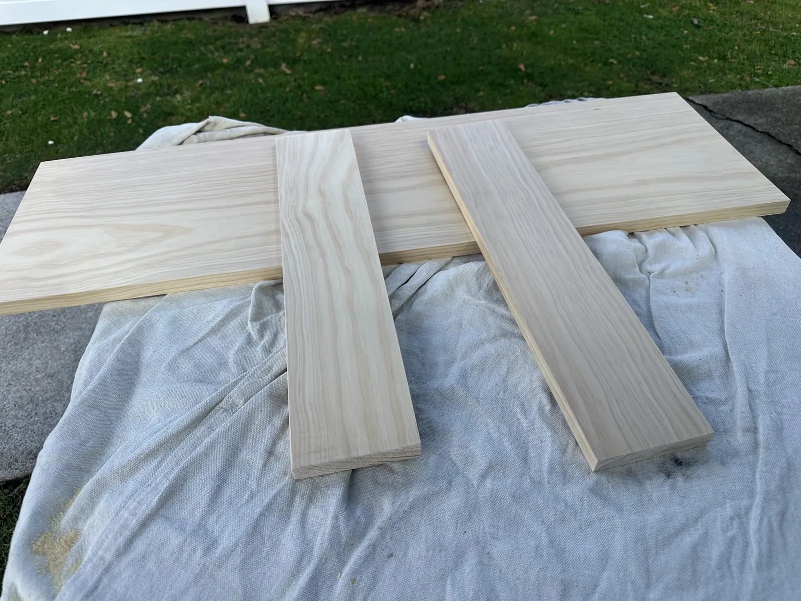 Four cut timber pieces for a custom picture frame laid out on a dropsheet