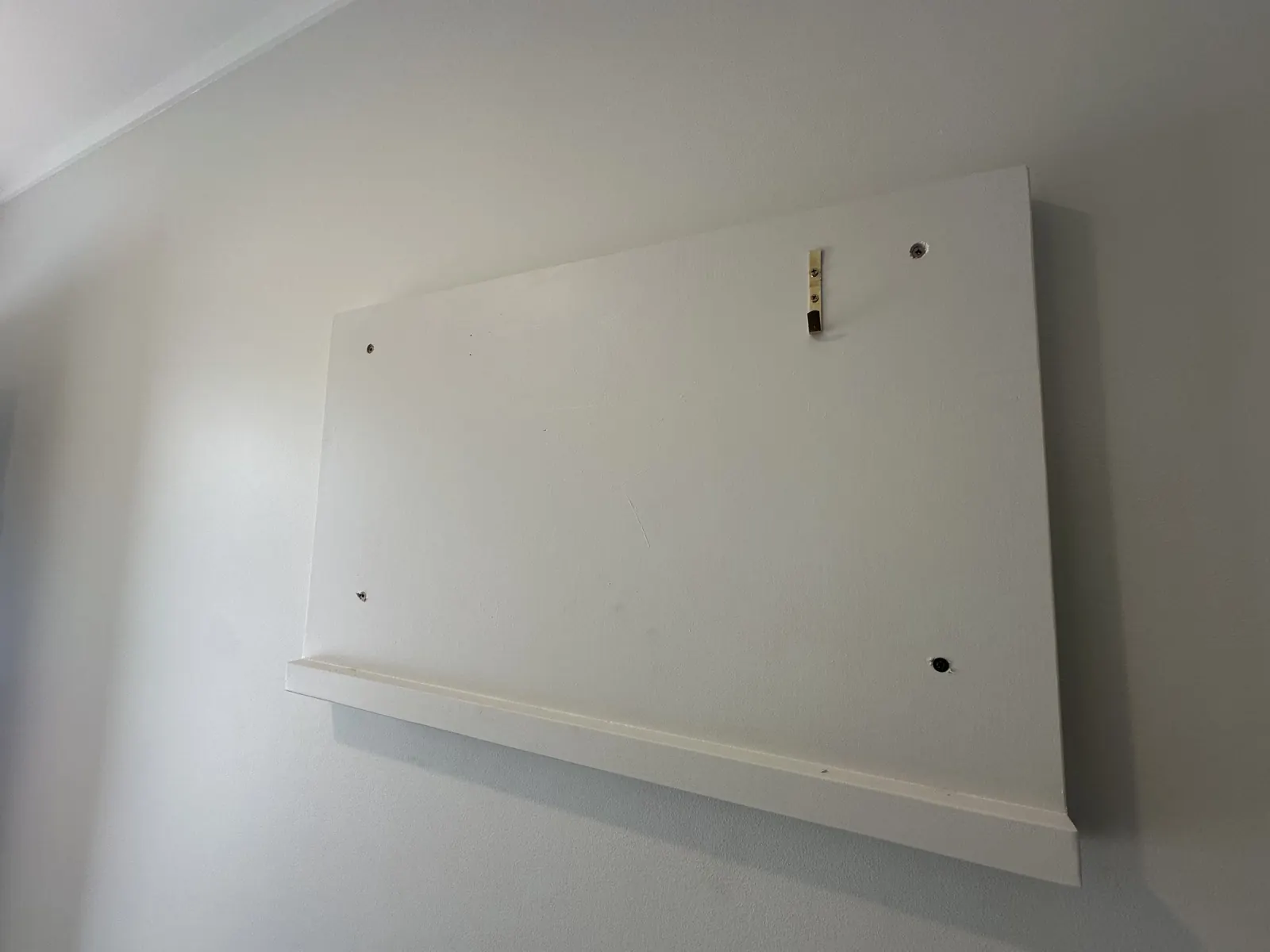 Painted timber picture frame mounted level on the wall before the panel goes in