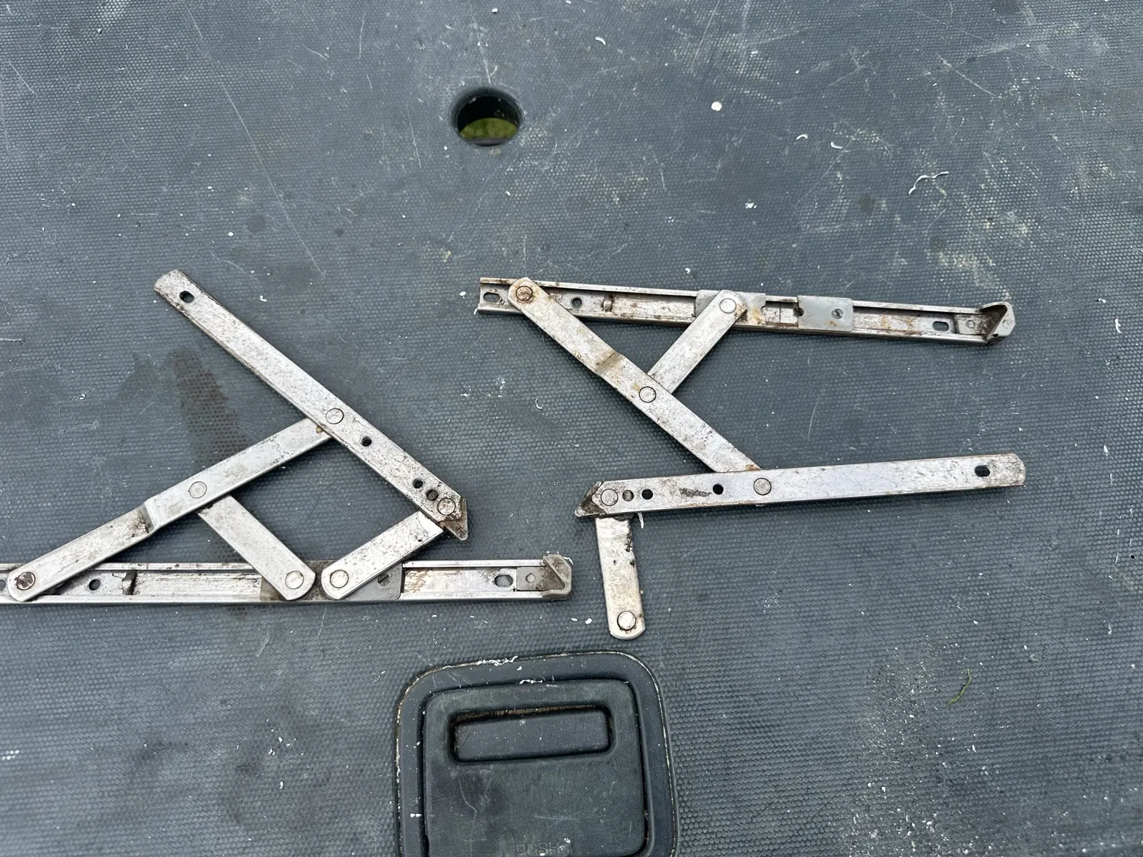 The two old friction stays off the window, one of them visibly bent out of shape