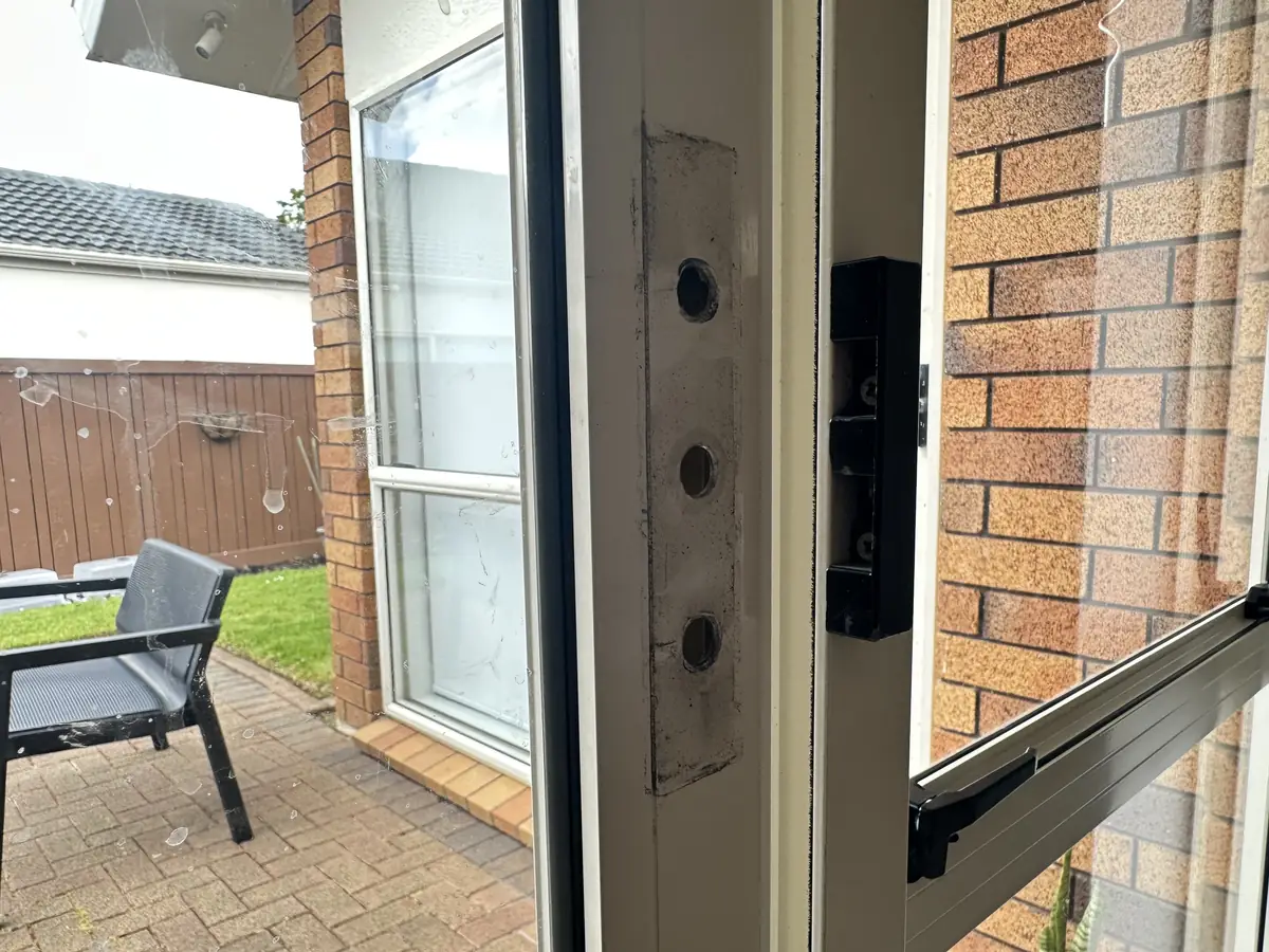Edge of the sliding door in Botany with the lock removed, showing the empty mortise, three fixing holes and the keeper on the jamb