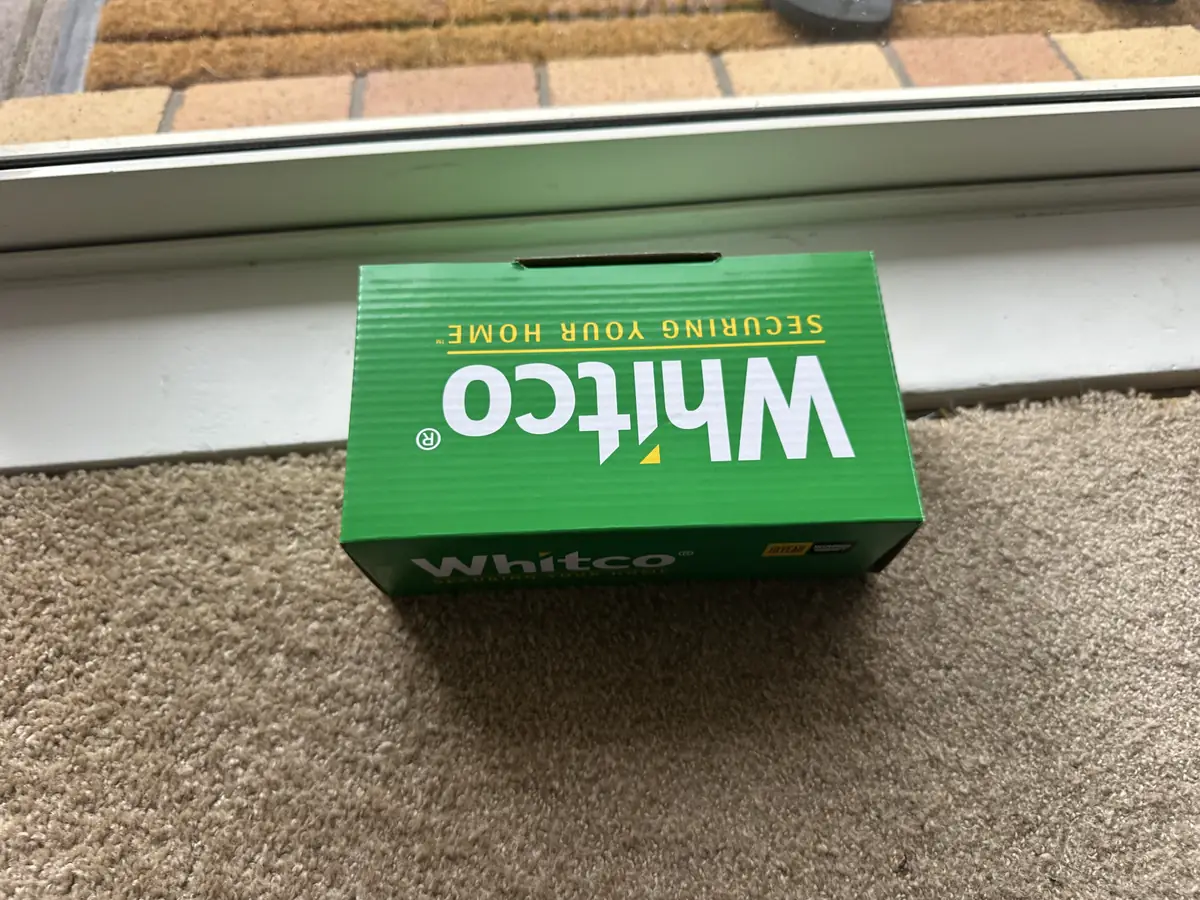 New Whitco keyed sliding door lock in its green box, sitting on the door track in the Botany house