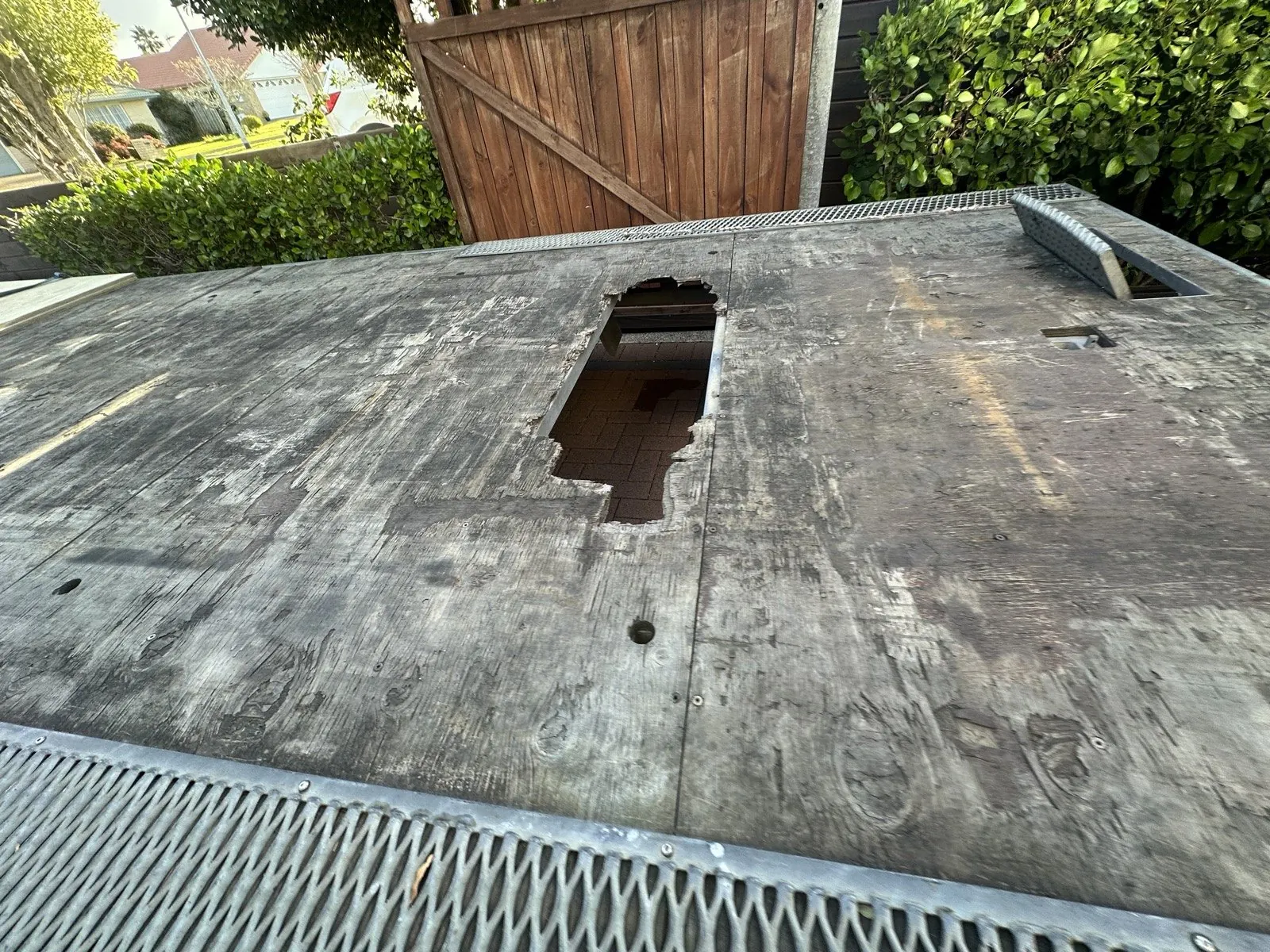 Close-up of the rotted plywood on the trailer deck, open right through to the driveway below