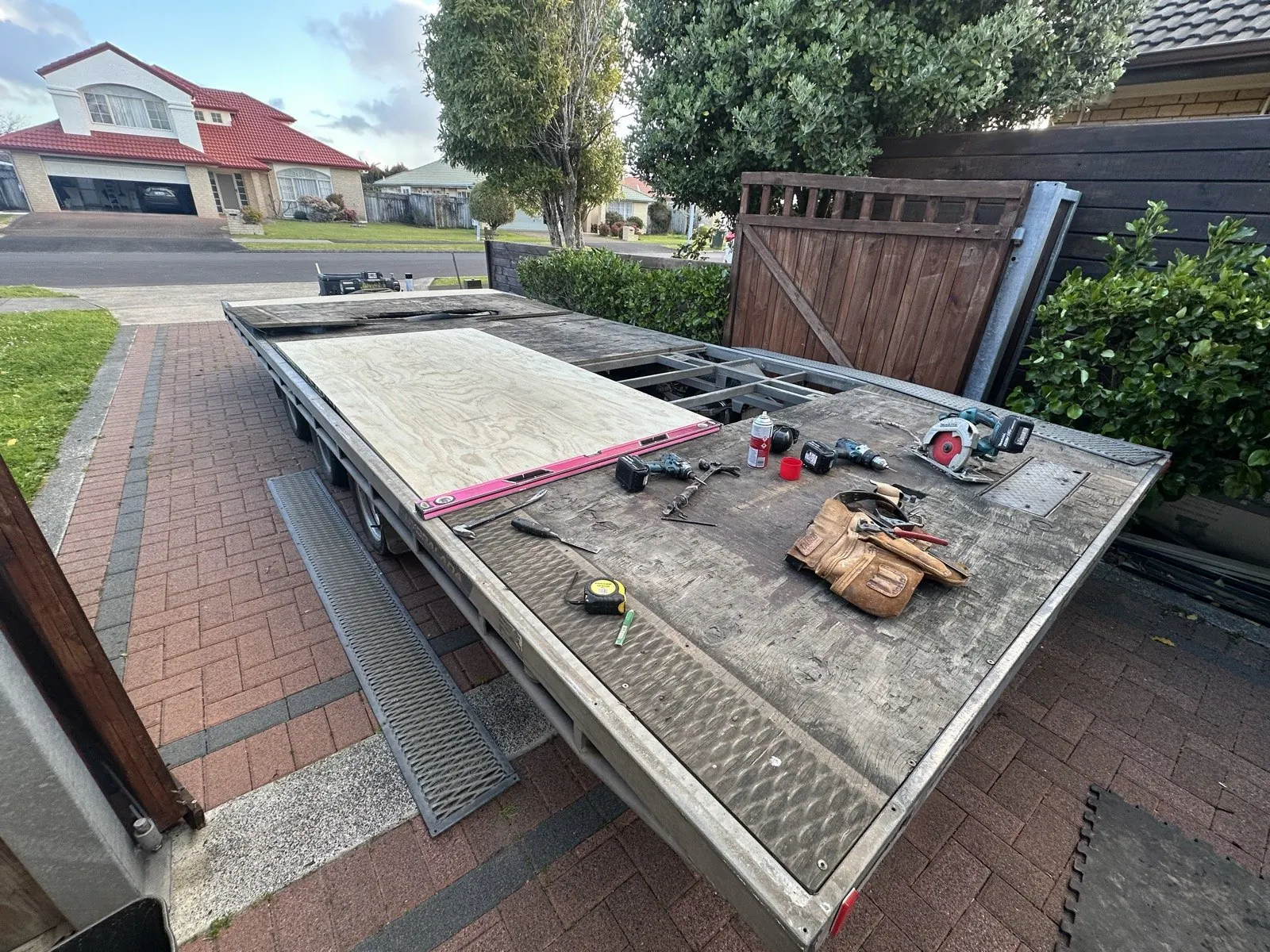 New plywood panel cut and fitted into the trailer deck, with the steel frame visible alongside