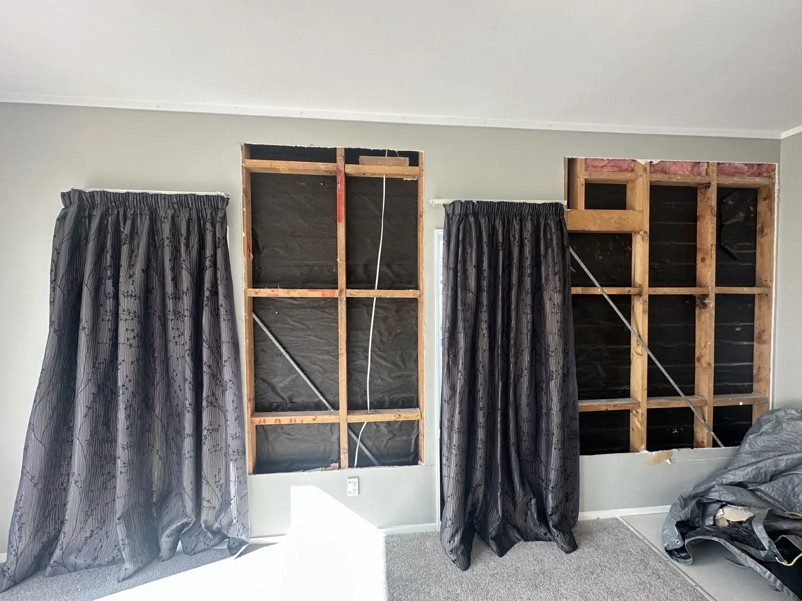 Both wall openings stripped back to bare framing and building paper, left open to dry in Highland Park