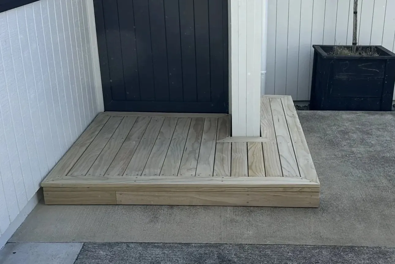 Before and after comparison showing a concrete entrance transformed with new timber decking in Cockle Bay
