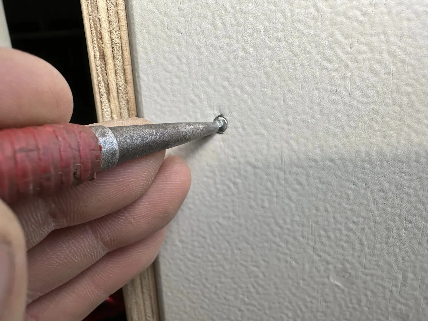 Finishing nails punched below the surface of the new garage door jamb ready for final finishing