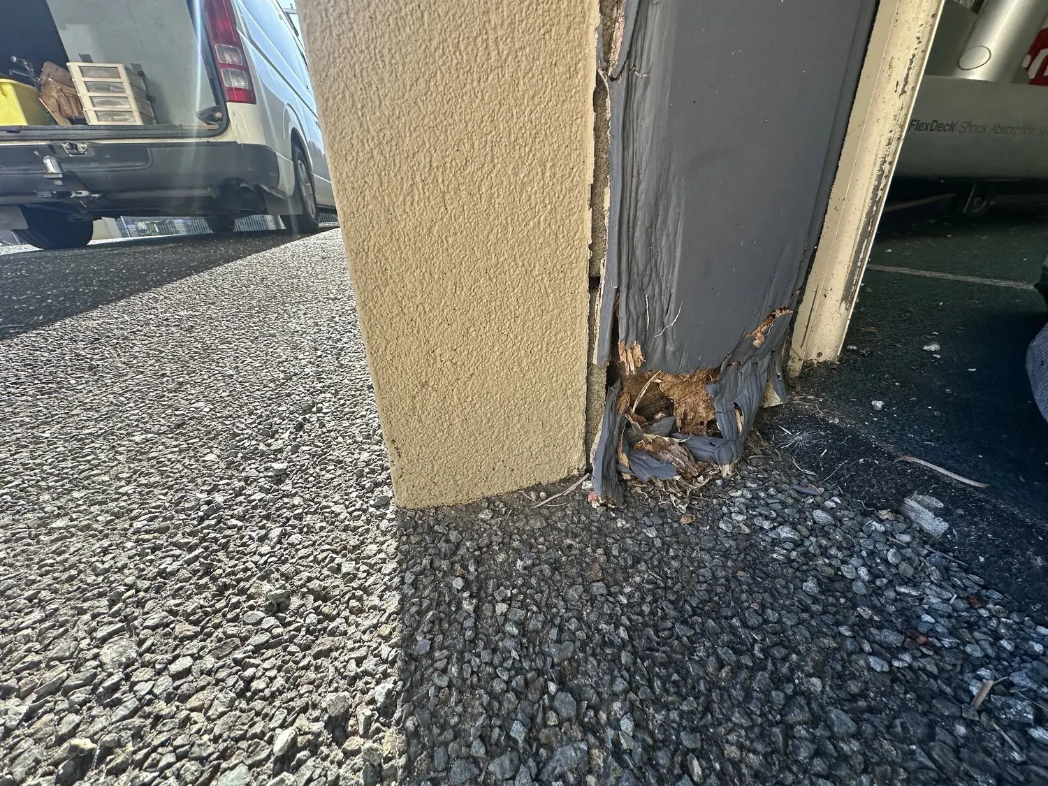Close-up of severe timber rot at the bottom of a garage door jamb in Somerville